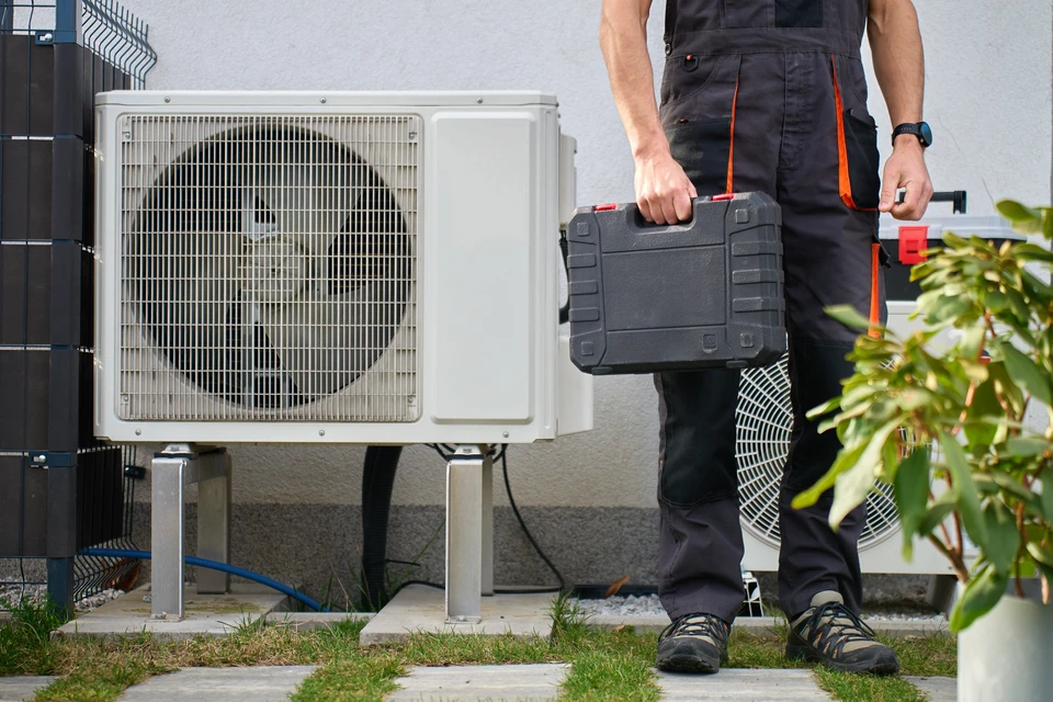 Technicien en chauffage travaillant sur une installation de chauffage central dans un local technique